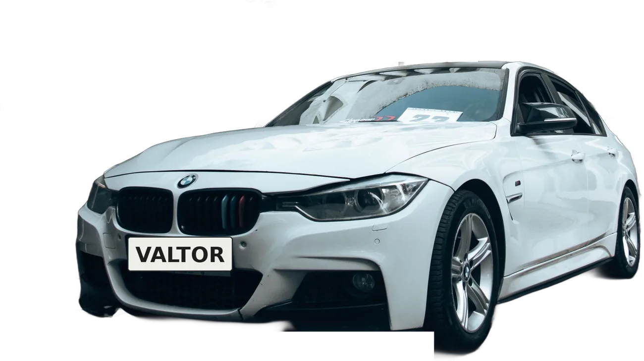 Auto sedán blanco recién detallado, con pintura brillante y rines limpios